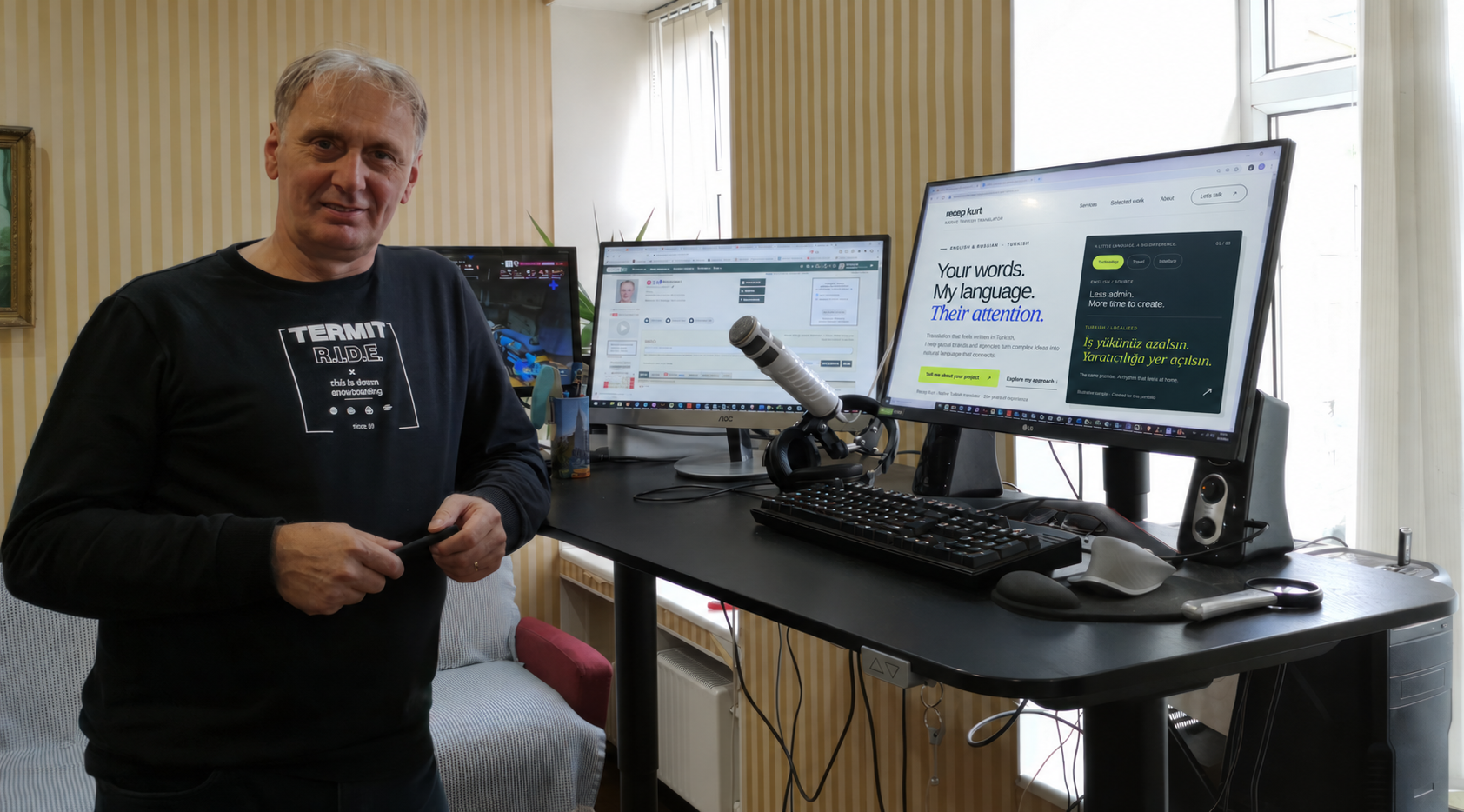 Recep Kurt at his desk with his translation website displayed on the right-hand monitor